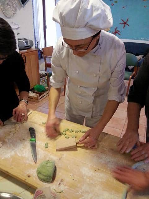 Dimostrazione pratica della preparazione degli gnocchi Chef in divisa mostra come si preparano gli gnocchi verdi a mano.