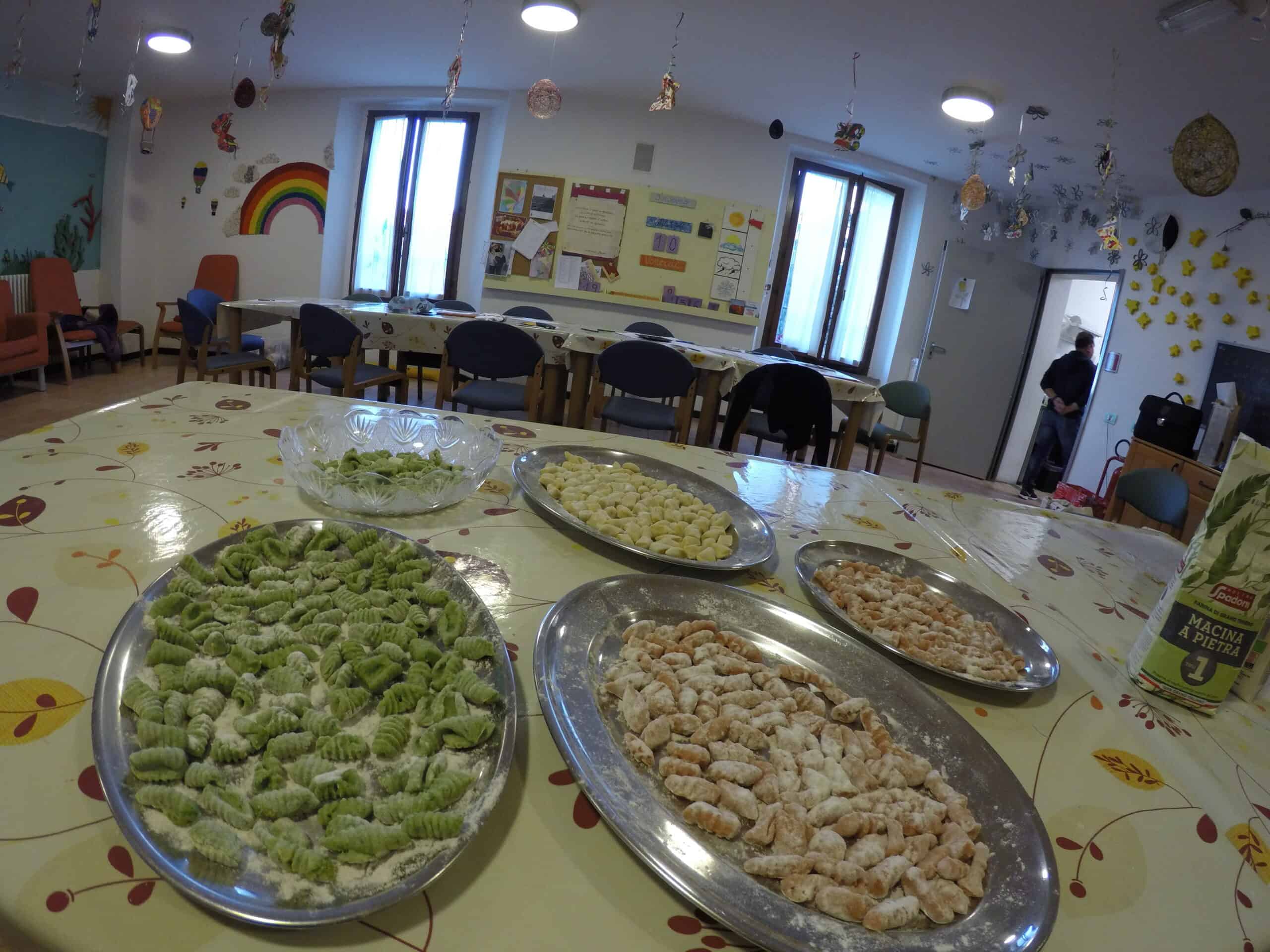 Gnocchi artigianali in fase di preparazione Vassoi con gnocchi verdi, bianchi e arancioni pronti per essere cucinati.