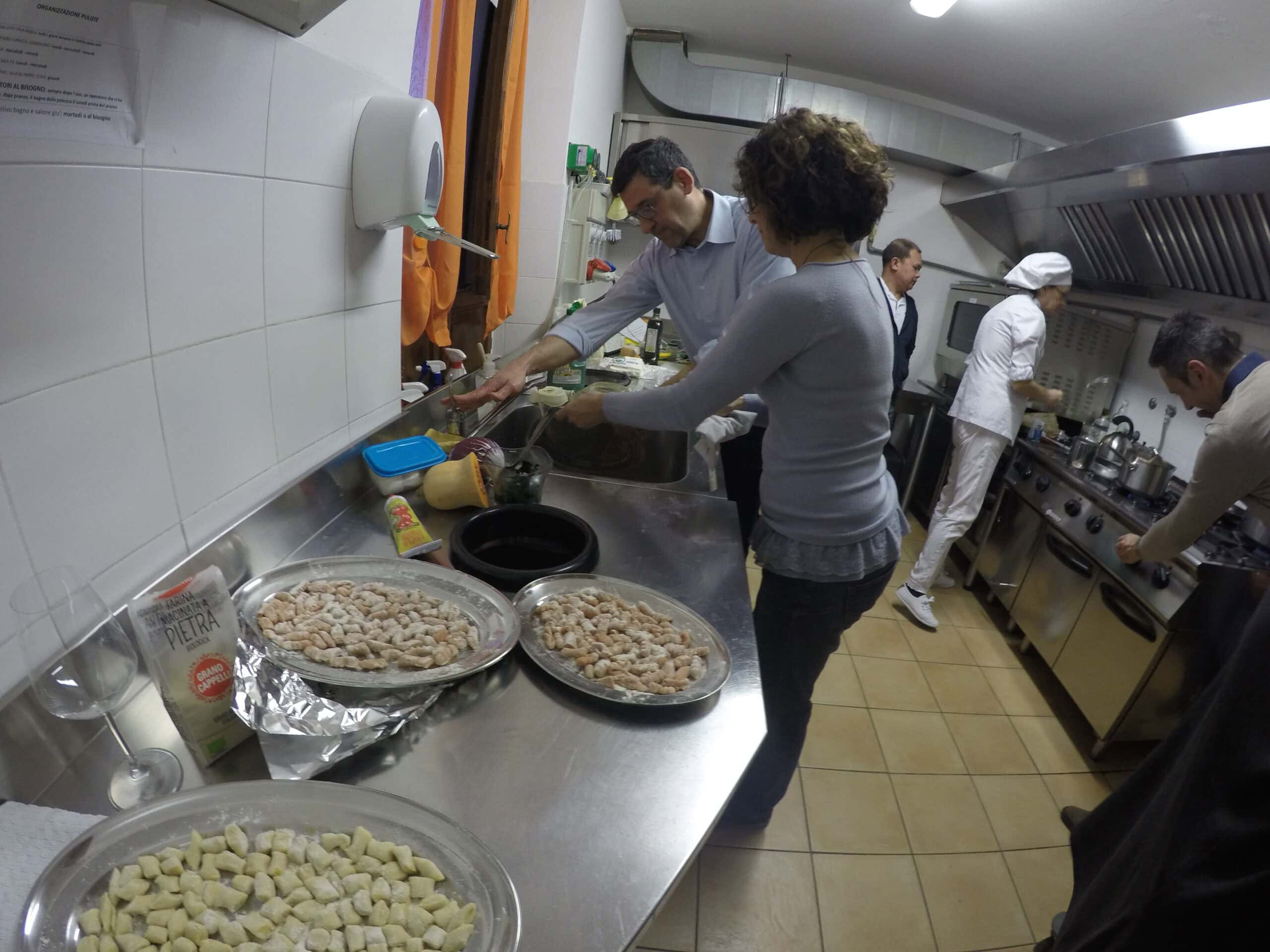 Partecipanti in cucina durante il corso Gruppo di partecipanti e chef impegnati nella cucina durante la preparazione dei piatti.