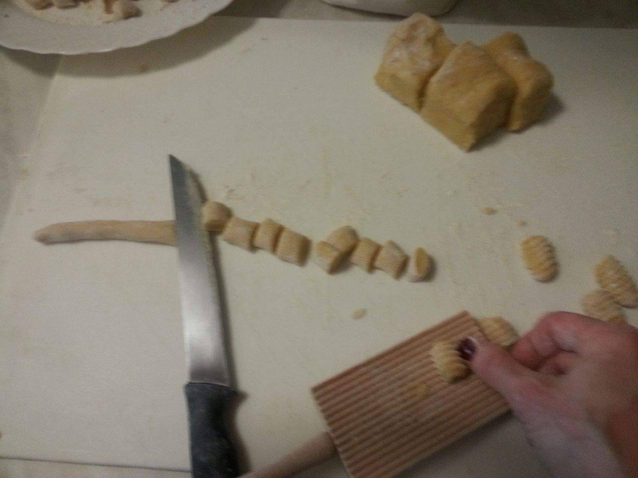 preparazione-gnocchi-bianchi.jpg Taglio e formatura a mano degli gnocchi bianchi su tavolo da cucina, durante la cooking class.