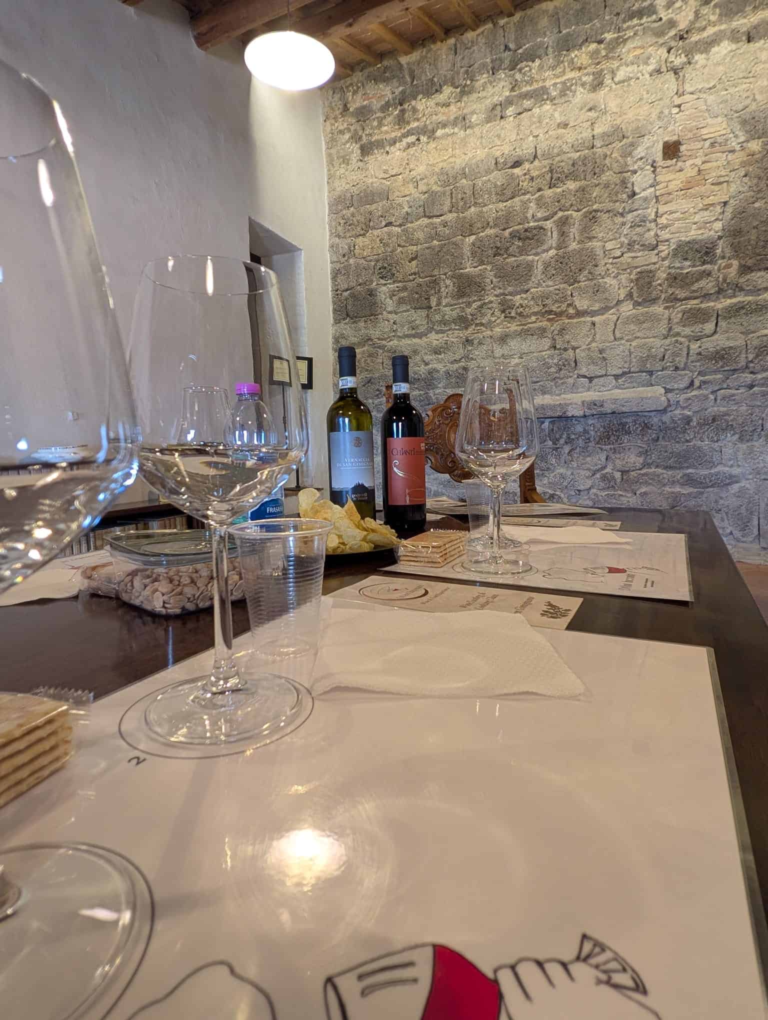 Close-up of Tuscan wine glasses and bottles on a branded tasting mat